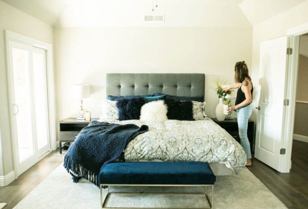 woman adjusting items on the bedside table