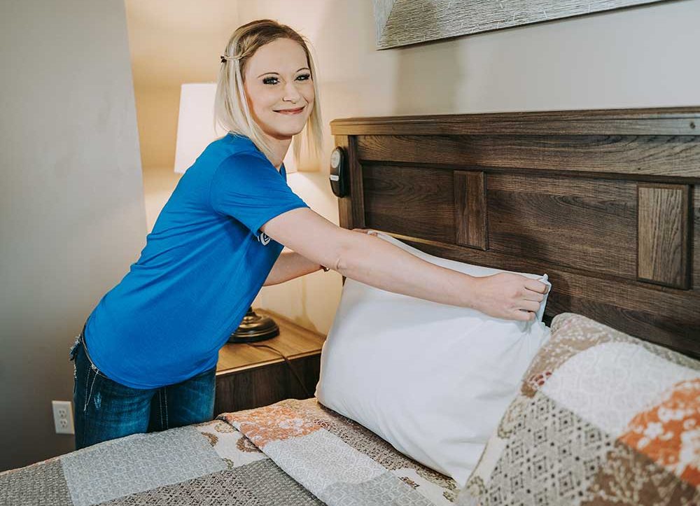 woman adjusting the bed pillow