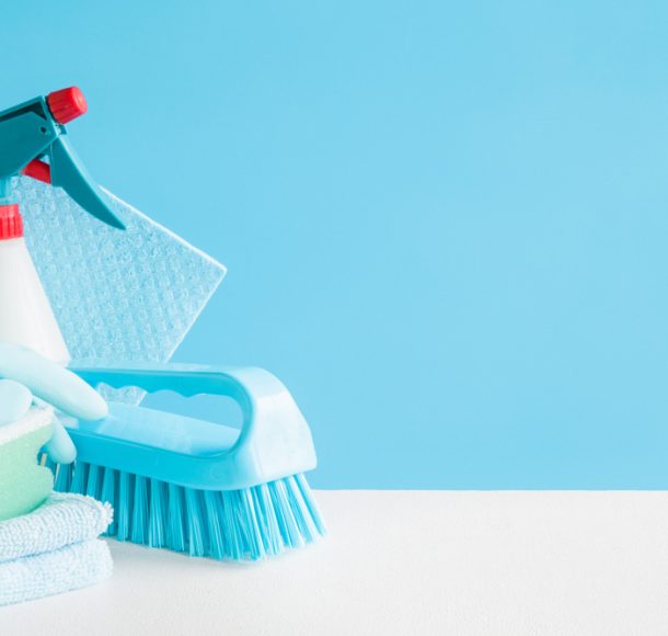 Gloved cleaner wiping a kitchen counter with a cloth.