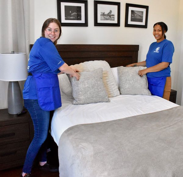 two women tidying up a bedroom