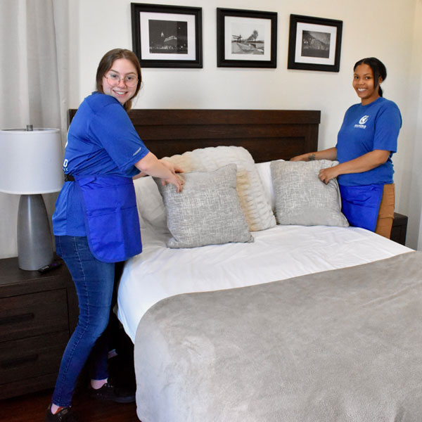two women tidying up a bedroom